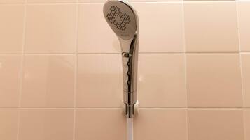 A showerhead mounted on a wall with a white pipe.