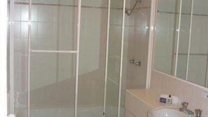 A bathroom with a bathtub, a sink, and a mirror. - Sails Resort on Golden Beach Unit 03 (Golden Beach)