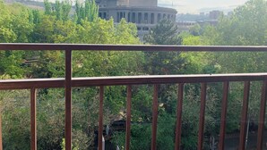 A view of a building with classical architecture, surrounded by lush greenery.