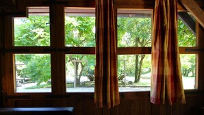 Una habitación con paredes de madera y un ventanal con cortinas.