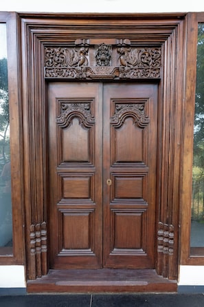 Una puerta doble de madera con tallas complejas y un escudo de armas.