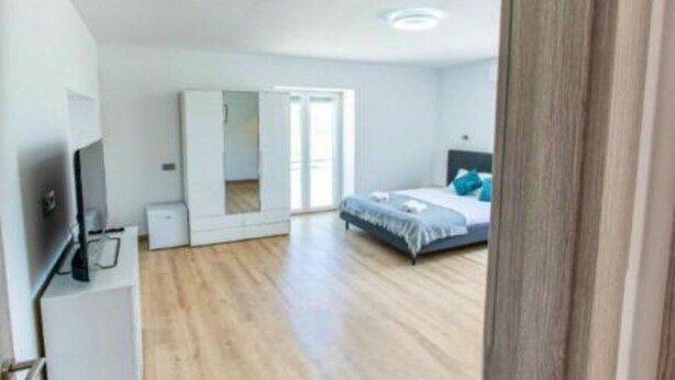 Une chambre à coucher avec un lit, une télévision et une armoire.