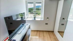 A compact room with a window, a built-in desk, and a door. - Rooms Burnum - Double Room 3 (Vrbnik-Knin)