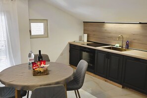 Eine moderne Küche mit eingebautem Backofen, einer Spüle und einem Fenster über der Arbeitsfläche.
