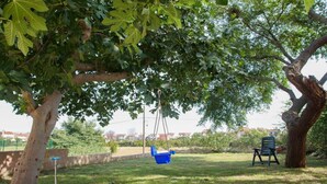 A tree with a swing hanging from its branches, a bench, and a grassy area with a fence in the background. - Apartments Manda - One Bedroom Apartment With Terrace (A1) (Fazana)