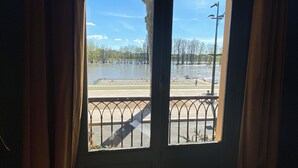 Ikkunasta avautuu näkymä tulva-alueelle, aidalle ja kirkkaalle taivaalle.