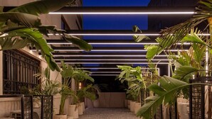 A pathway leading to a building entrance, flanked by potted plants and a modern light fixture. - 22 By Spacey (#47) | Studio in Maadi (Cairo)