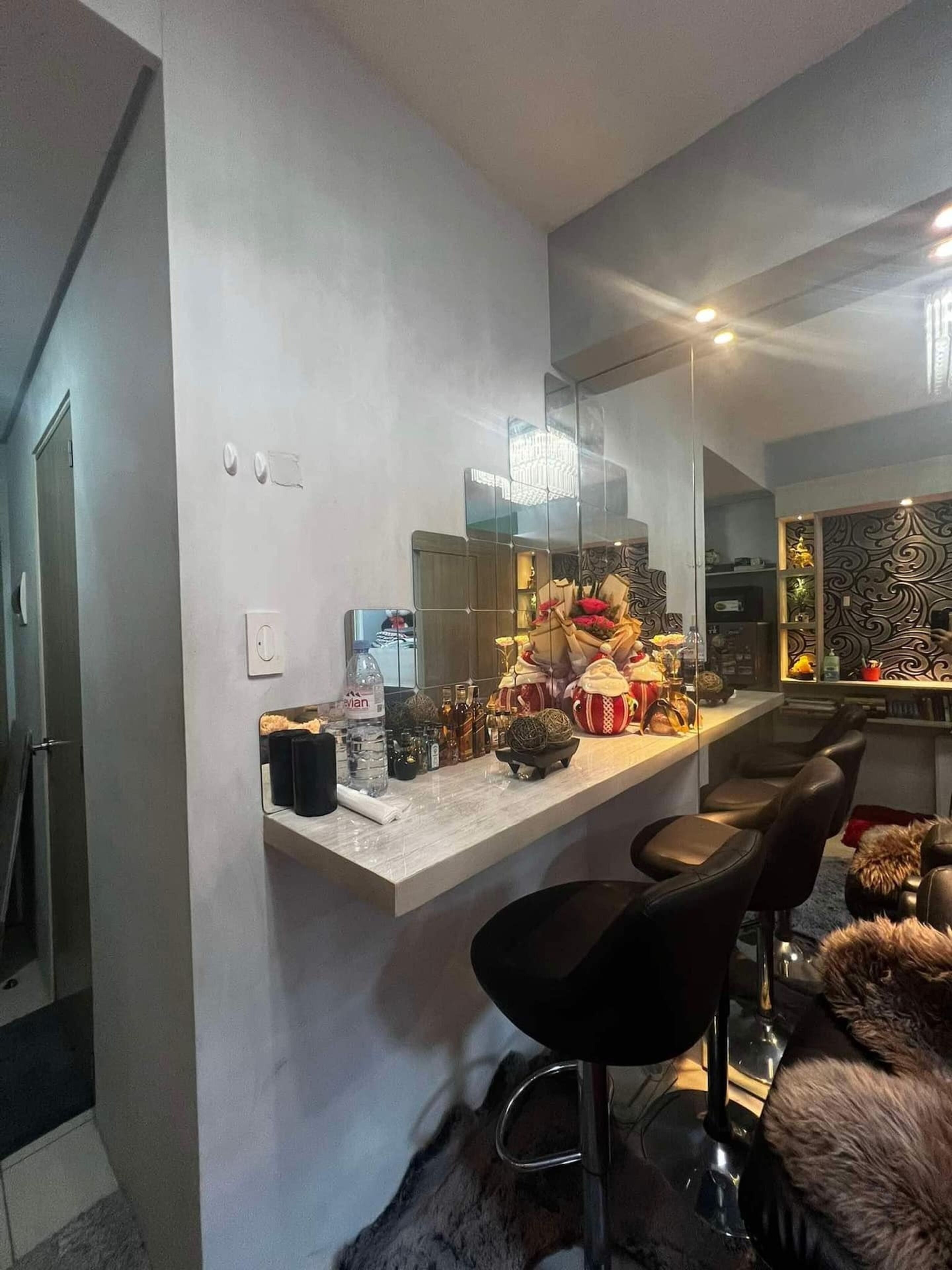 A modern kitchen with a marble countertop, a built-in wine rack, and a seating area with a fur throw.