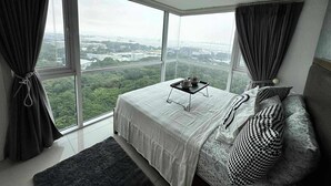 A modern bedroom with a large bed, a view of a cityscape, and a city view through the window. - Breeze Residences Condos (Pasay)