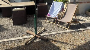 An outdoor seating area with a table, two chairs, and a large umbrella. - The maples - sainte maure de Touraine (Sainte-Maure-de-Touraine)