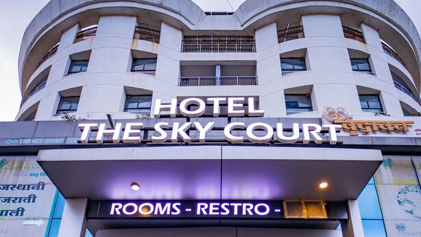 A hotel entrance with a sign reading "Hotel The Sky Court" and "Rooms - Restro". - The Sky Court - An Hospitality (Chhatrapati Sambhajinagar)