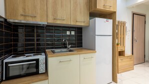 A kitchen with wooden cabinets, a built-in oven, a sink, and a refrigerator. - N&S Fms, Cozy two bedroom apartment close to Fleming Metro station (Thessaloniki)
