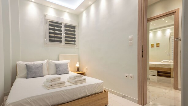 A modern bedroom with a large bed, bedside lamps, and a skylight. - N&S Fms, Cozy two bedroom apartment close to Fleming Metro station (Thessaloniki)