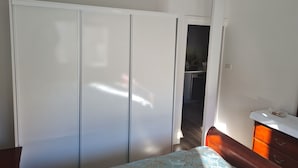 Une chambre à coucher comprenant un lit, une armoire, une commode et un ventilateur de plafond.