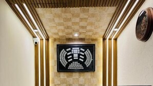 Una recepción con un diseño de pared a cuadros, un emblema enmarcado y tiras de iluminación verticales.