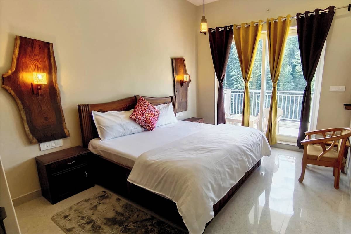 A bedroom with a large bed, a wooden nightstand, a chair, and a balcony view.