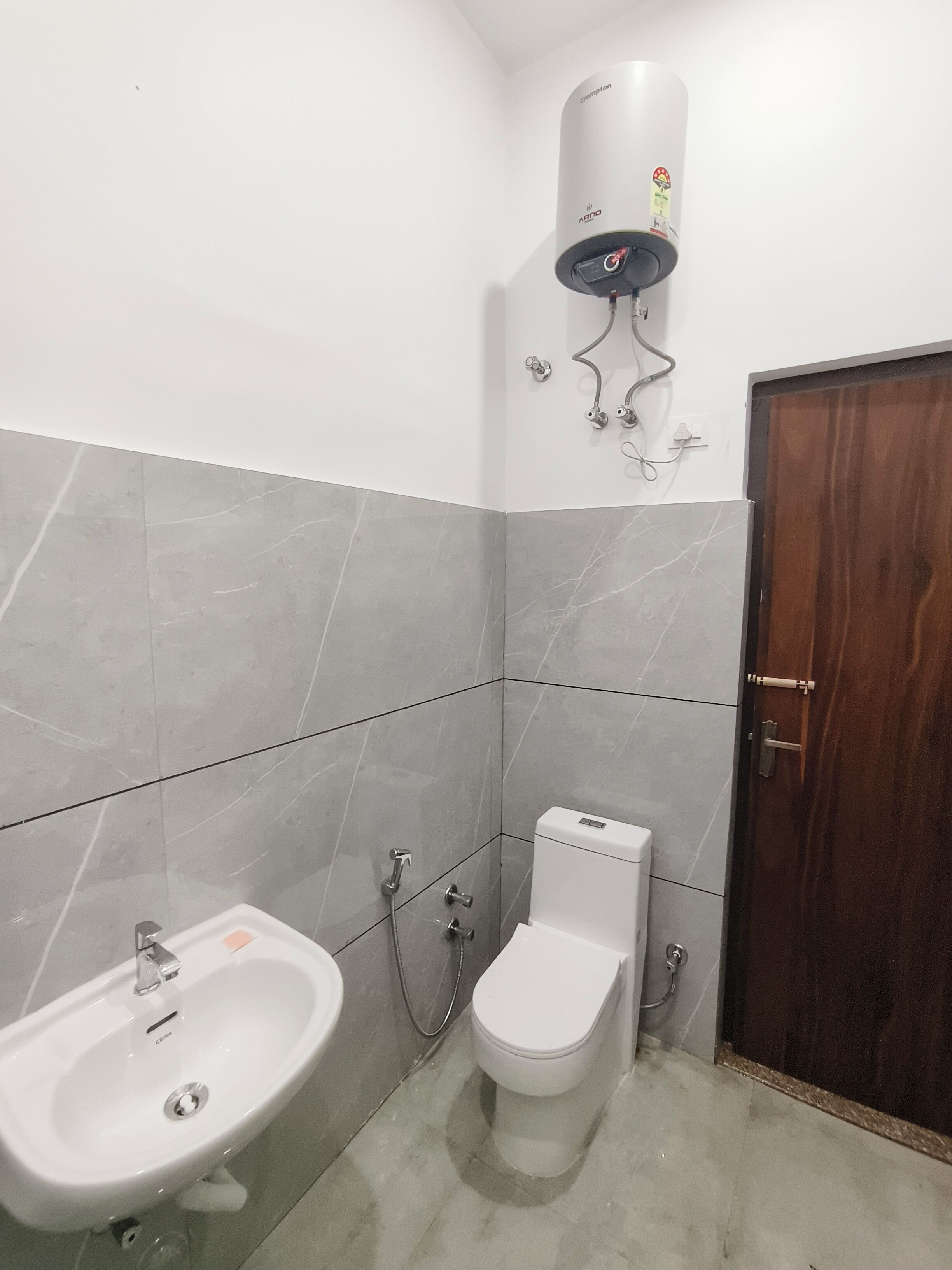 Une salle de bain avec un lavabo blanc, des toilettes et une douche.