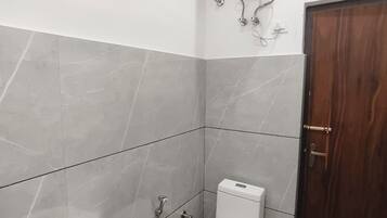 Une salle de bain avec un lavabo blanc, des toilettes et une douche.