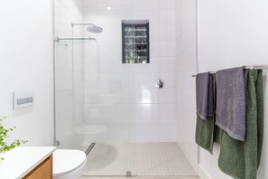 Een haardroger, handdoeken, zeep, toiletpapier