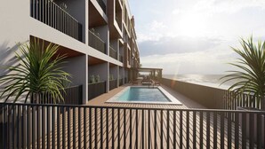 Un bâtiment moderne doté d’une piscine, d’un espace extérieur aménagé et offrant une vue sur l’océan.
