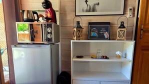 A compact kitchen with a refrigerator, a kettle, and a toaster. There is a shelf with a framed picture and a small lantern. - gites o fil de l'eau (Omessa)