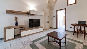 A modern living room with a TV, wooden console, and a patterned rug. - Sardinia 10 - Lecce Selection (Lecce)