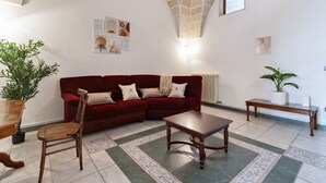 A living room with a red sofa, wooden coffee table, and a patterned rug. - Sardinia 10 - Lecce Selection (Lecce)