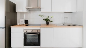 A modern kitchen with white cabinets, a stainless steel refrigerator, a built-in oven, and a sink. - Studio Anid - Lecce Selection (Lecce)