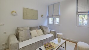 Un salon moderne avec un canapé, une table basse et une fenêtre avec des rideaux.