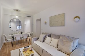 Een moderne woonkamer met een eethoek, een bank en een ronde spiegel.