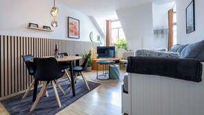 Un salon moderne comprenant un coin repas, un téléviseur et un canapé confortable.