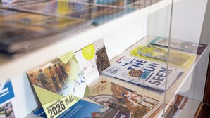 Une collection de brochures et de dépliants est exposée sur une étagère en verre.