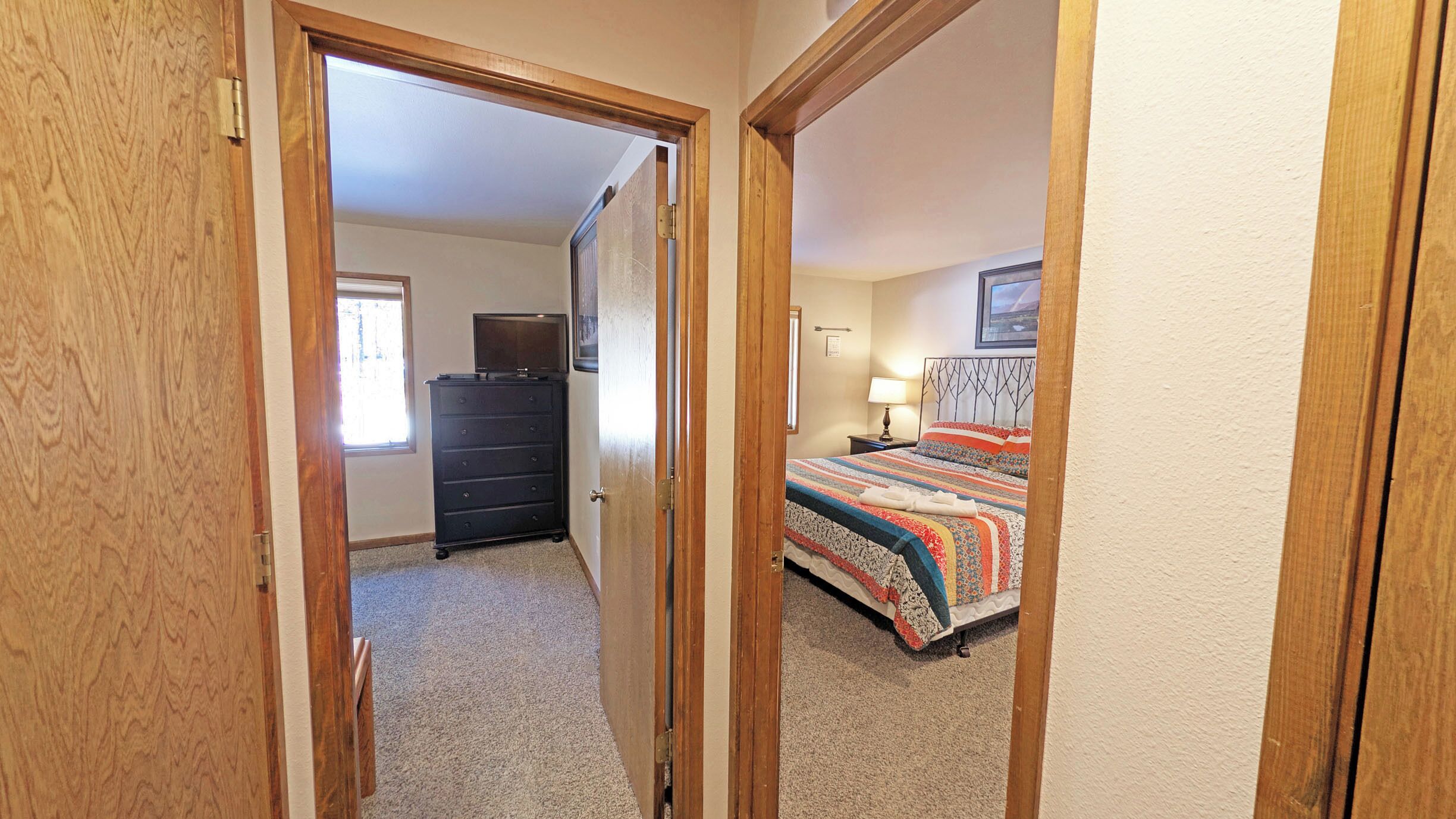 Un dormitorio con cama, cómoda, ventana y puerta.