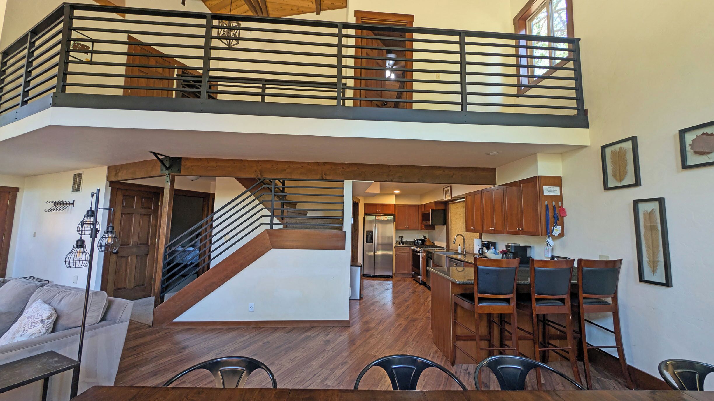 A spacious loft-style apartment with a mezzanine, open kitchen, and dining area.