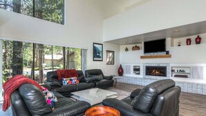 A modern living room with leather sofas, a coffee table, and a fireplace.