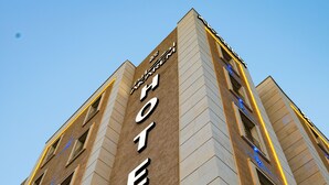 A hotel building with a prominent 'HOTEL' sign on the facade. - Akarem Jazan Serviced Apartments (Jizan)