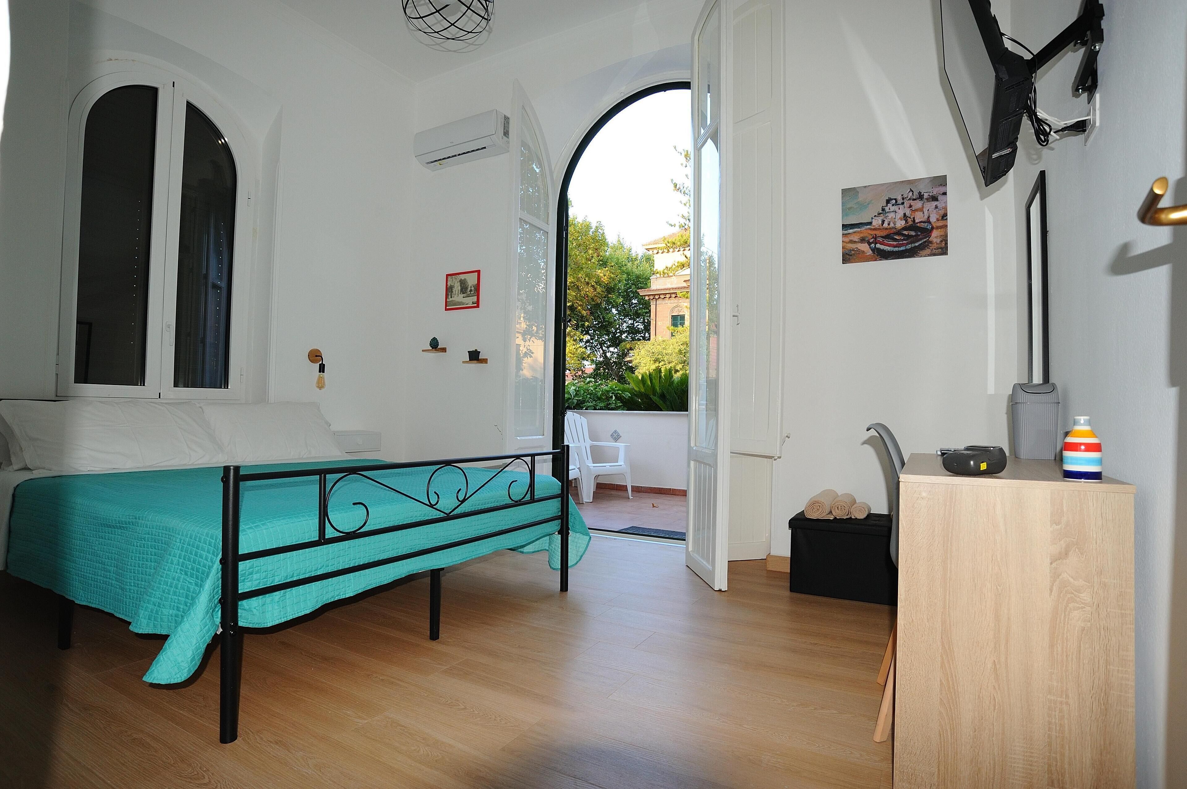 Een slaapkamer met een bed, een bureau en uitzicht op buiten.