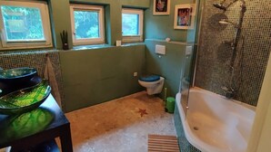 A bathroom with a bathtub, a toilet, and a sink.