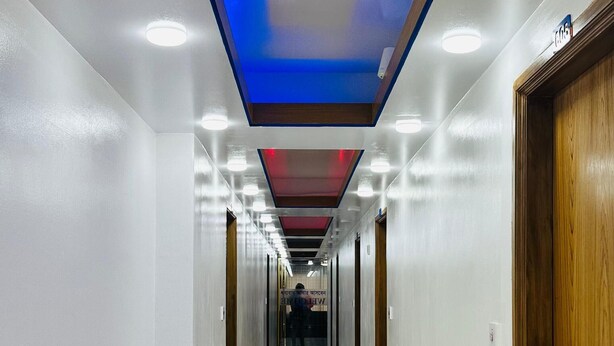 A long, narrow hallway with white walls and a tiled floor. - The Imperial Residence Banani (Dhaka)