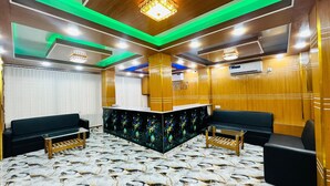 A reception area with a wooden reception desk, black sofas, and a marble-patterned floor. - The Imperial Residence Banani (Dhaka)