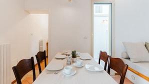 A dining area with a table set for four, chairs, a small plant, and a sofa with cushions. - Terrace Le Colonne - Lecce Selection (Lecce)