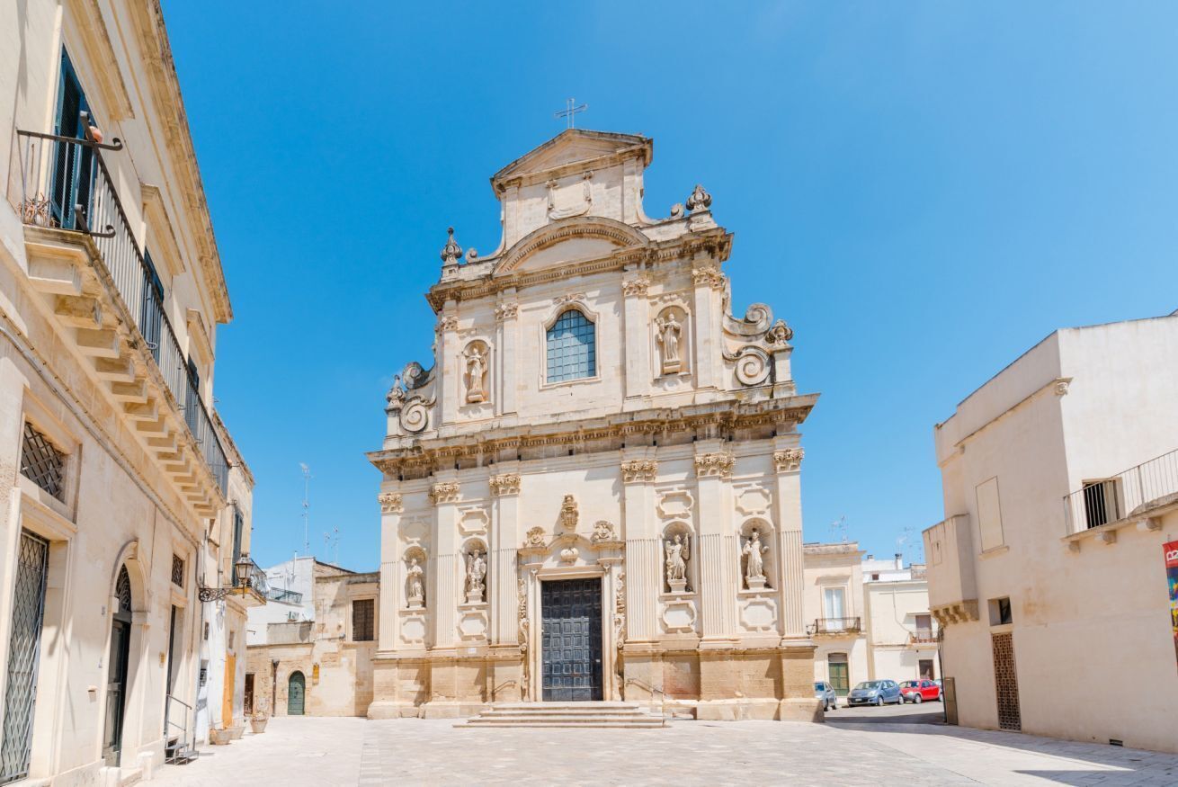 A historic church with a central dome and ornate facade, surrounded by narrow streets.