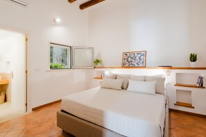 Une chambre à coucher avec un lit, une fenêtre donnant sur un beau paysage, une table de chevet et une étagère fixée au mur.