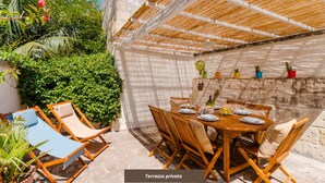 A private terrace with a wooden table set for dining, surrounded by wicker chairs, and a shaded area with a woven roof. - Terrace Le Colonne - Lecce Selection (Lecce)