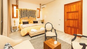 Un dormitorio con una cama, una silla, una mesita y una puerta de madera.