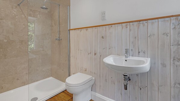 A bathroom with a shower, toilet, and sink.
