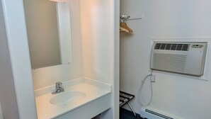 Une petite salle de bain compacte avec un lavabo blanc, un miroir et un radiateur fixé au mur.