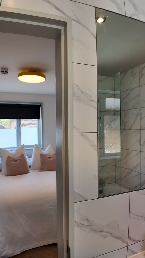 A modern bathroom with marble tiles and a glass shower enclosure. - Anerley (London)
