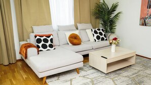 En moderne stue med en sofa, et sofabord og en potteplante.