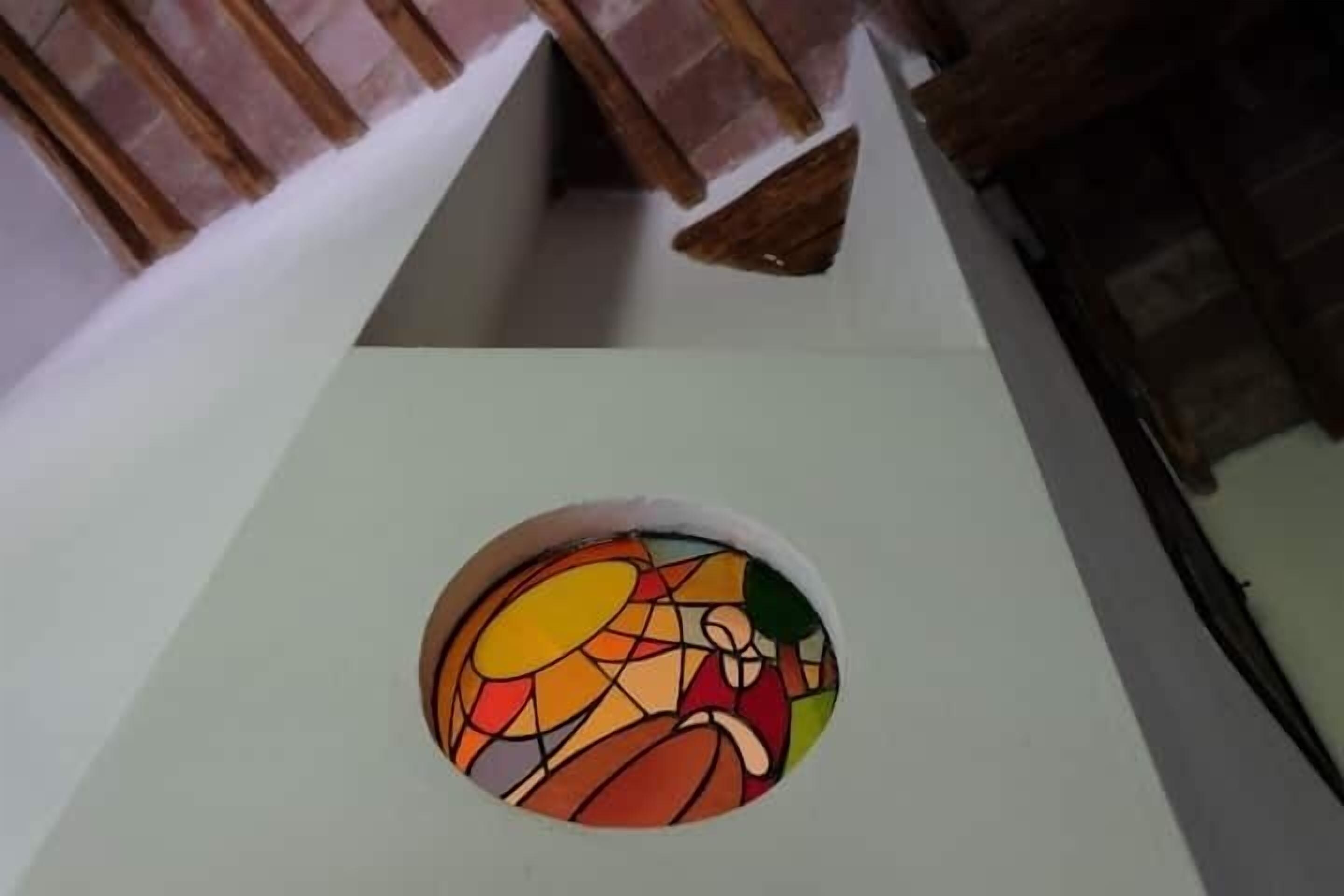 Ein rundes Buntglasfenster mit abstrakten Mustern.
